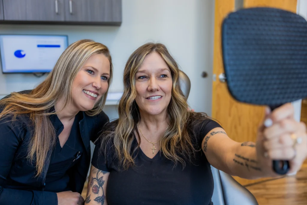 Restore in 24 patient smiling after dental implants with team member in Woodstock, GA